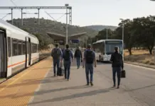 Renfe reconoce que el tren rápido Cáceres-Badajoz viaja por debajo de lo previsto y pide más autobuses Viajeros caminando por el andén de una estación de tren extremeña junto a un tren regional detenido, con un autobús urbano esperando a la salida, en alusión a la conexión entre el tren Cáceres-Badajoz y el transporte urbano