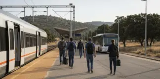 Renfe reconoce que el tren rápido Cáceres-Badajoz viaja por debajo de lo previsto y pide más autobuses Viajeros caminando por el andén de una estación de tren extremeña junto a un tren regional detenido, con un autobús urbano esperando a la salida, en alusión a la conexión entre el tren Cáceres-Badajoz y el transporte urbano