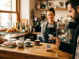 Adiós al cartón de sellos: el pequeño comercio digitaliza su tarjeta de fidelización Un cliente escanea con su móvil el código QR de una tarjeta de fidelización digital colocado en el mostrador de una cafetería de barrio
